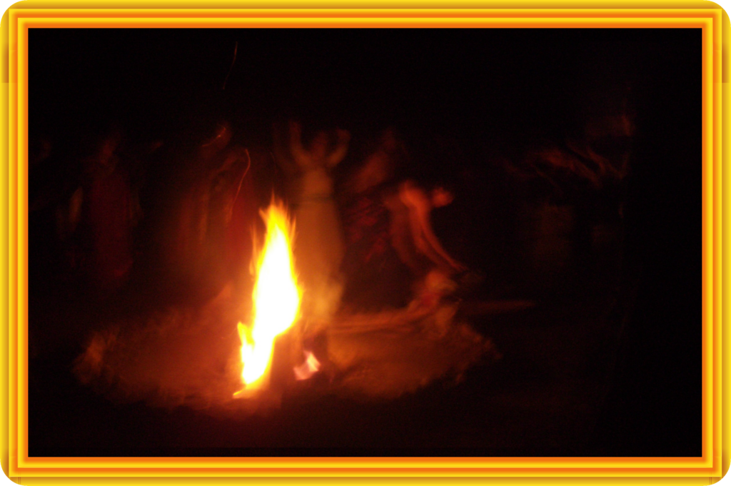 image of a bonfire in the dark ,surrounded by shadowy women