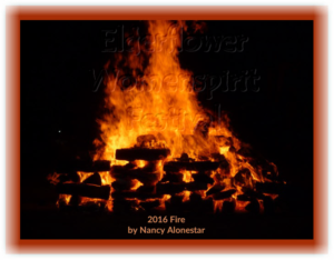 Main ritual fire with high orange flames surrounded by darkness